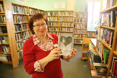 Võrumaa keskraamatukogu raamatukoguhoidja Anu Kasak näitab lugejate hulgas üht populaarsemat raamatut, „Minu”-sarja kuuluvat „Minu Eesti” esimest osa. Foto: Võrumaa Teataja