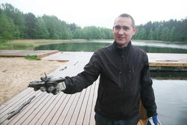 Tamula ja Kubija järvede rannavalvepunktide juht Romet Lehtla näitab vee alt välja toodud lauajuppi koos naelaga. Foto: INNO TÄHISMAA