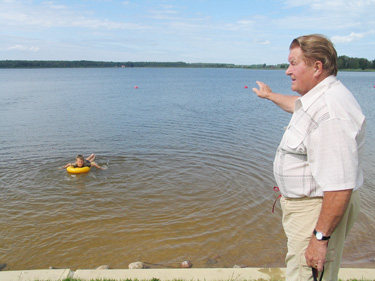 Vambola Sulg (pildil) näitas eile Tamula rannas, et startida tuleb üle järve asuva maja punase katuse suunas ja tagasi ujudes võtta sihiks üheksakordne tornelamu Tartu–Kreutzwaldi tänava nurgal. Eile ennelõunal oli Tamula järve veetemperatuur 20 kraadi.  Foto: VÕRUMAA TEATAJA