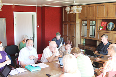 Pildil kuulavad Haanja vallavolikogu liikmed neljapäeval Ruusmäe sotsiaalmajas peetud istungil majaelaniku Lembit Truija (pildil tagaplaanil) seletust kütte hinna kohta. Paremal laua otsas istub volikogu esimees Silver Näkk.   Foto: Võrumaa Teataja