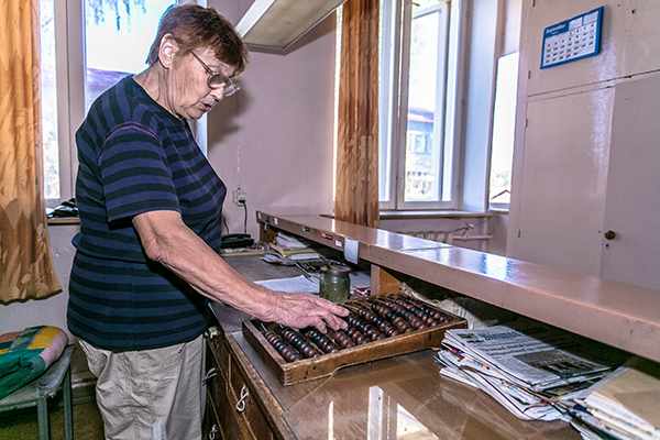 35 aastat legendaarses Jüri tänava kingatöökojas töötanud Silvi Eksin teeb viimaseid arvutusi arhailisel arvelaual.