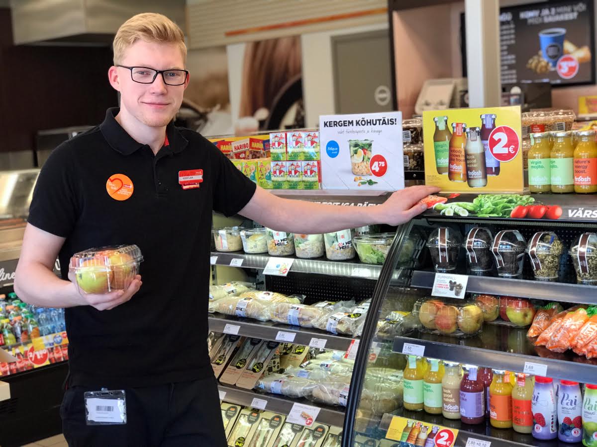 Võru Circle K Jüri tänava teenindusjaama klienditeenindaja Kristjan Toots tervislikumaid toiduvalikuid soovitamas. Kollektiivi lemmik on näiteks Lapi leib soolalõhega. Sageli ostetakse porgandeid, mis ka lastele meelepärane vahepala on. Foto: KADI ANNOM