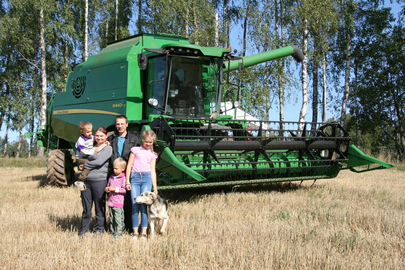 Hauka talu peremees Silver Dräbtsinski on end koos pereliikmetega sättinud ühele pildile, et demonstreerida 13 tonnist viljakoristuseks mõeldud kombaini kui oma uut pereliiget. Foto: HELERI LAKUR