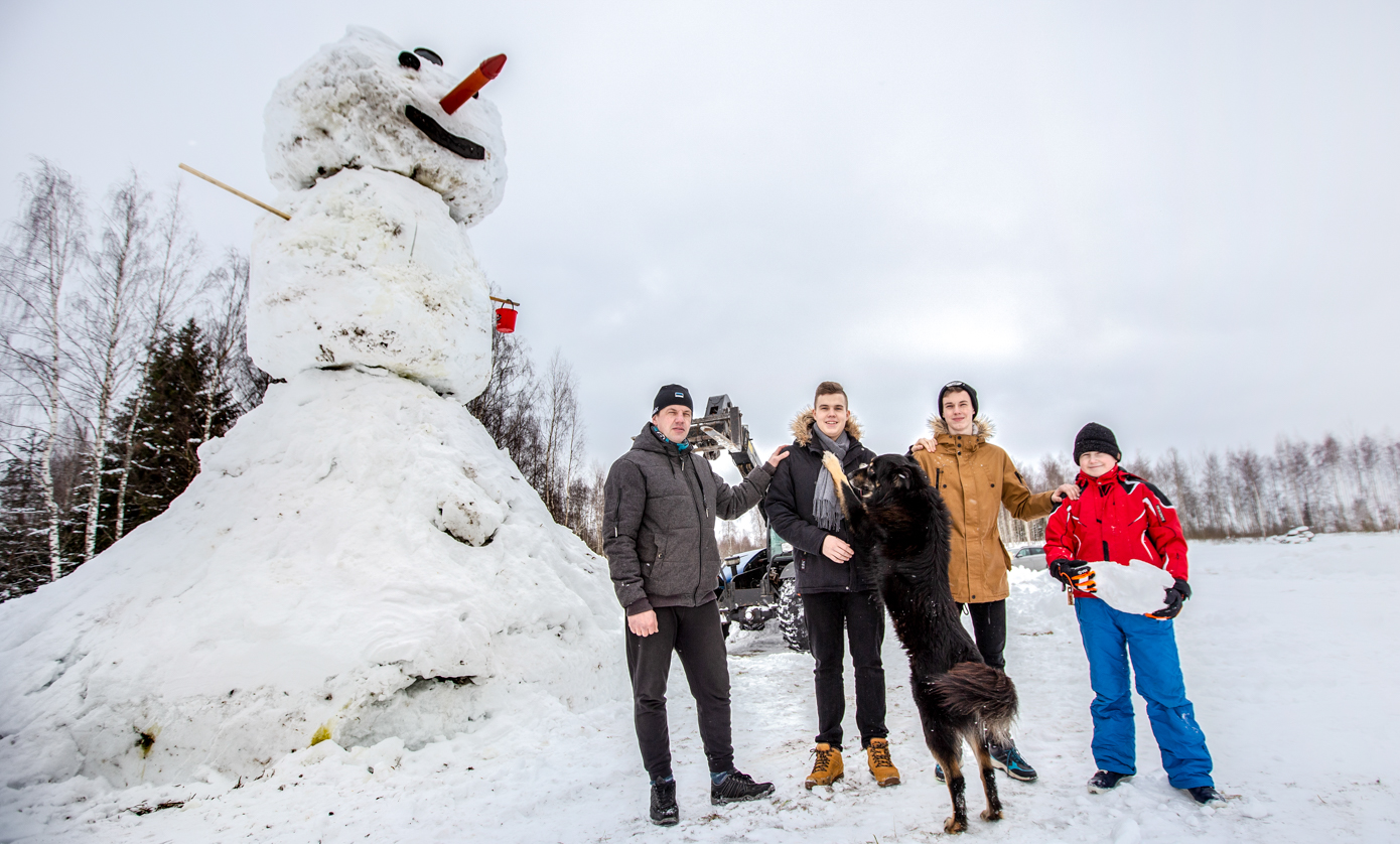Ivar Haabsaar koos poegade Rait, Ranek ja Robert Haabsaare ning koer Matuga. Taustaks ehituseks kasutatud masin ja kuulus lumemees, kellel silmadeks ja suuks puit ning ninaks kanalisatsioonitoru. Foto: AIGAR NAGEL