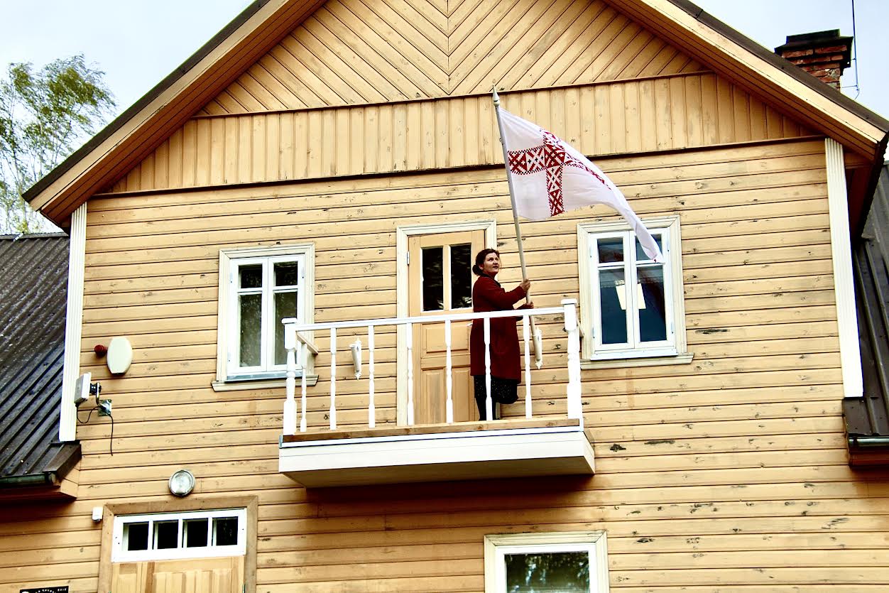 Setomaa Muuseumid direktor Merily Marienhagen, kes esines ka konverentsil, heiskab lippu Saatse muuseumi majale.