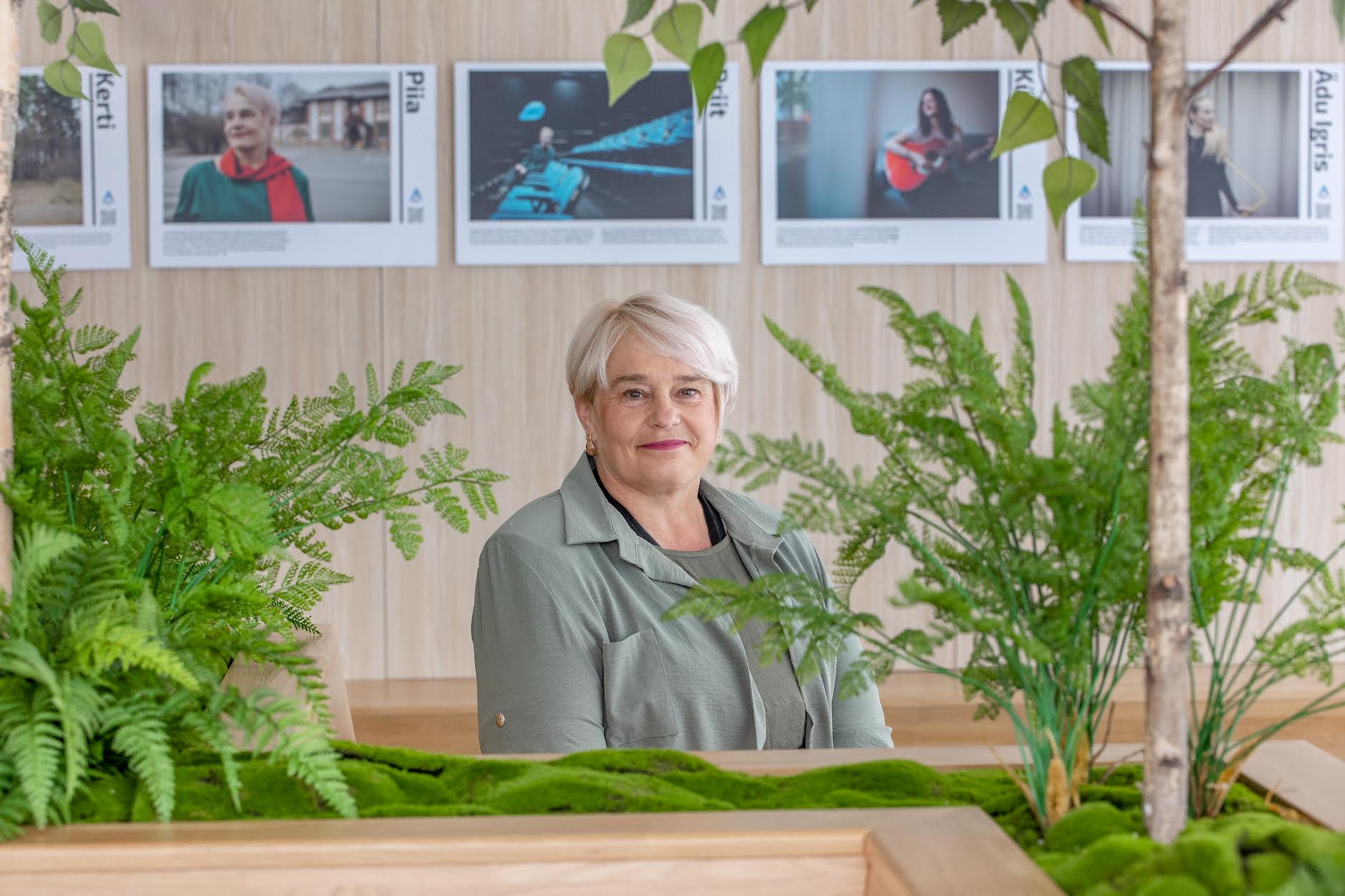 Piia Õispuu pea kohal on plakat tema enda tervise looga. Pimedatele mõeldud kirjeldustõlge tutvustab seda plakatit nii: “Sügis. Portreefotol keskealine, heledapäine naeratav naine. Tal on roosaka varjundiga sassoon poisipea ehk külgedelt lühikeseks pöetud, tukk veidi tõstetud. Hoolikas jumestus: tumedad kulmud ja pikad ripsmed, erkpunased huuled. Tema pea ja pilk on suunatud paremale. Piial on seljas tumeroheline, ümara kaelusega kleit. Erkpunane sall on ümber kaela, üks ots langeb ette vasakule rinnale ja teine ots üle õla selja taha. Kõrvas on väike, rippuv, läbipaistva kiviga kõrvarõngas. Foto taust on ühtlaselt hajutatud, udune.” Kirjeldustõlke koostajad Piret Aus ja Kai Kunder. Foto: Aigar Nagel