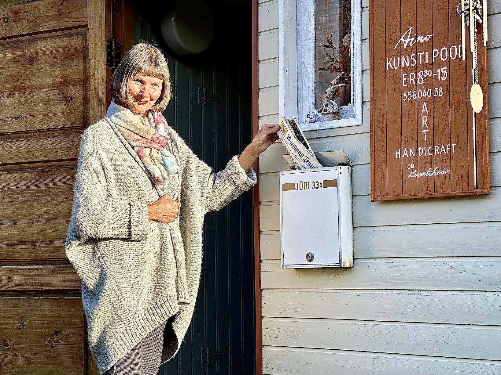 Aino Tamberg oma kunstipoe uksel. FOTO: Kalev Annom