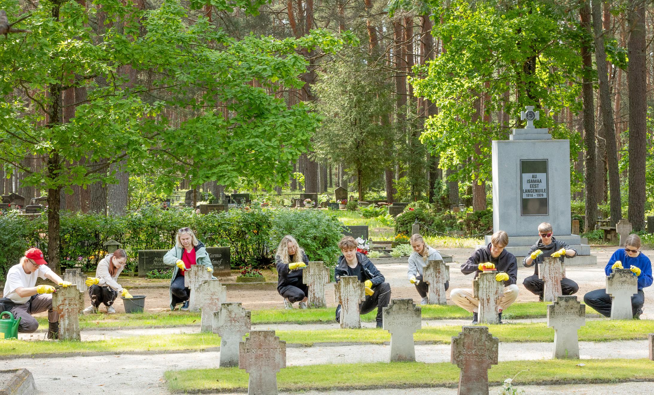 Alfred Hurt (vasakult), Karolin Saare, Maivi Liiskmann, Merit Hass, Simo Sulg, Anna-Grete Kuusik, Lasse Rihard Sissas, Uku Udras, ja Annabel Kipasto. Võru kalmistul pesti vee ja harjade abil puhtaks hiljuti renoveeritud vabadussammas ning vabadusvõitlejate haudadel olevad ajahambast puretud tähised. Fotod: Aigar Nagel