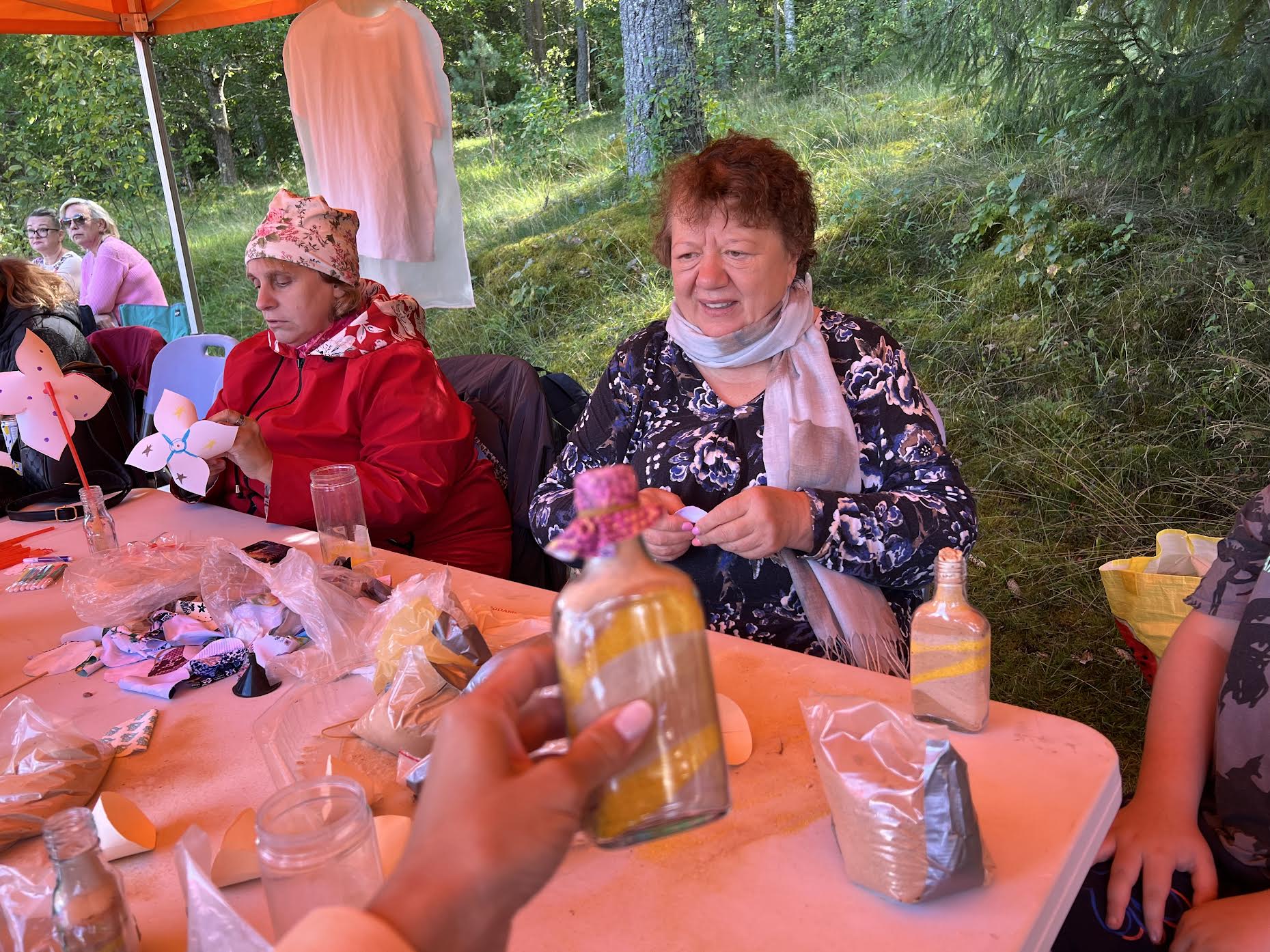 Lasva rahvamaja kultuurikorraldaja Sirje Kuuseorg (esiplaanil) õpetamas, kuidas teha dekoratiivseid liivapudeleid Piusa liivakarjäärist pärit eri värvi liivast. Fotod: VÕRUMAA TEATAJA Lasva rahvamaja kultuurikorraldaja Sirje Kuuseorg (esiplaanil) õpetamas, kuidas teha dekoratiivseid liivapudeleid Piusa liivakarjäärist pärit eri värvi liivast. Fotod: VÕRUMAA TEATAJA