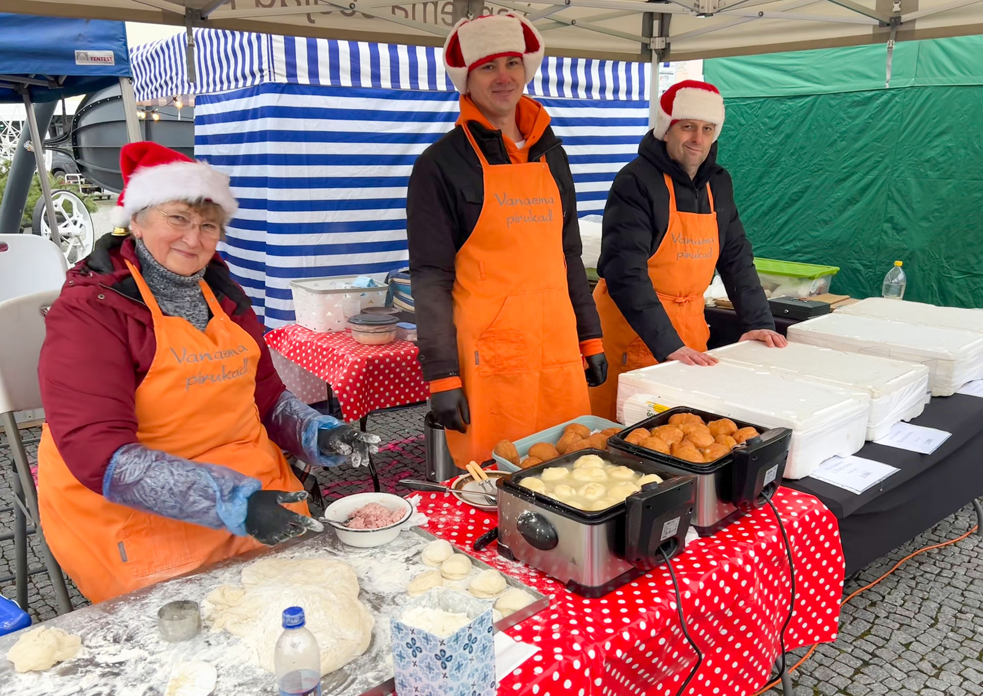 Päevasel ajal sai nautida esinejate tantsulusti, õppida ise tantse või nautida jõululaada melu. Heli Saar pakkus laadal ise tehtud pirukaid. Abiks pojad Siim Kõrkjas (vasakul) ja Sulev Saar. Foto: VÕRUMAA TEATAJA