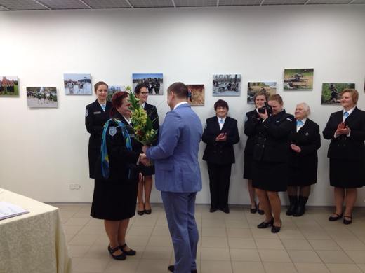 Maavanem Andres Kõiv õnnitleb Tartu rahu aastapäeva ja naiskodukaitse juubelinäituse avamise puhul ringkonna esinaist  Kaisa Peedosaart.