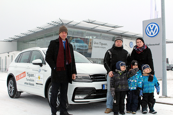 Võitja Peeter Truup koos perega Volkswageni  esinduses autot vastu võtmas. Tiguani andis üle müügidirektor Rein Kullamaa (vasakul). Foto: AIGAR NAGEL