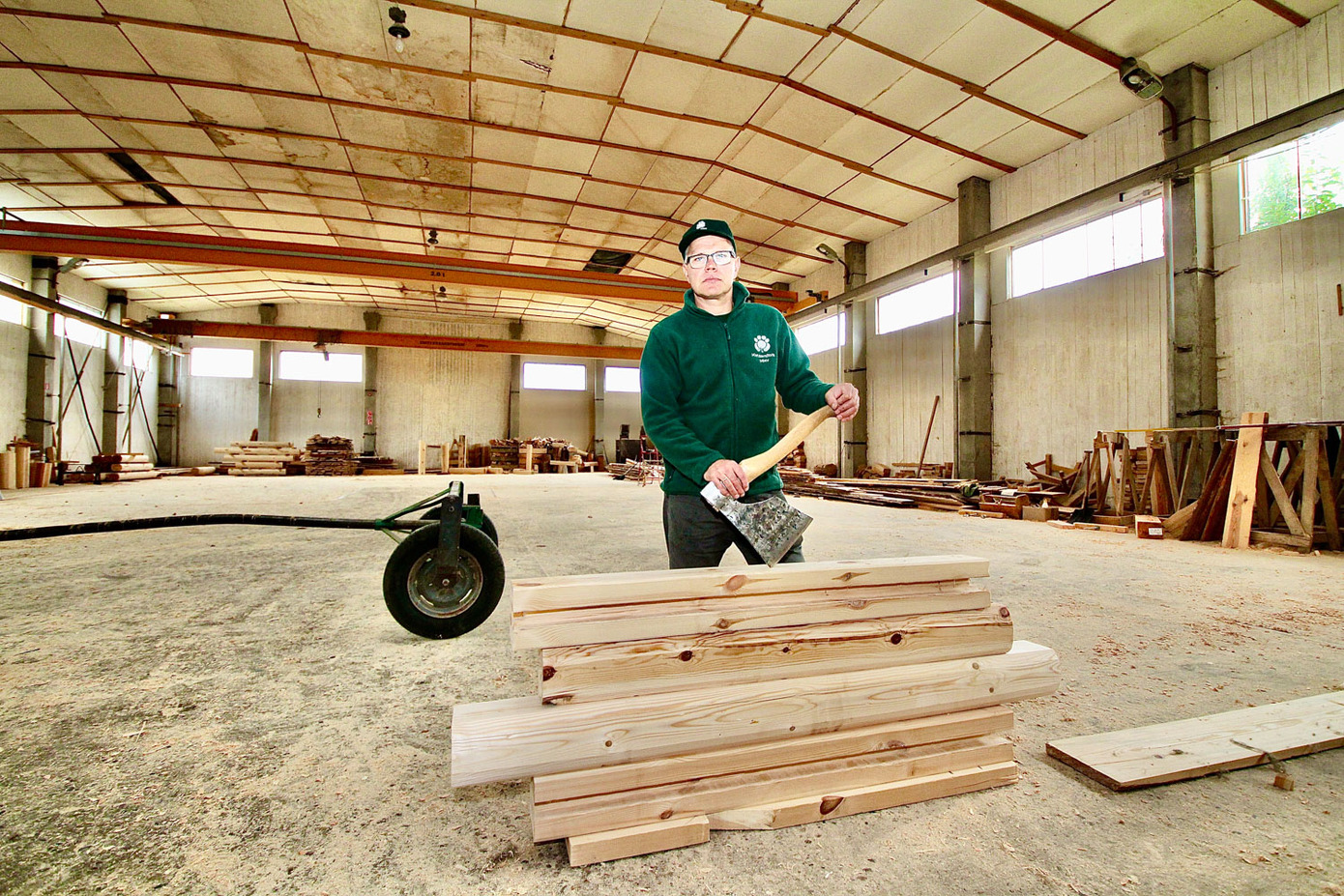 Taavi Tuvike 920 m2 puitmajade tootmishallis, käes spetsiaalne sepa valmistatud norra tapi tegemise kirves. Foto: KALEV ANNOM